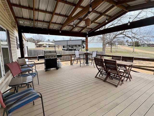 deck with a grill and outdoor dining area