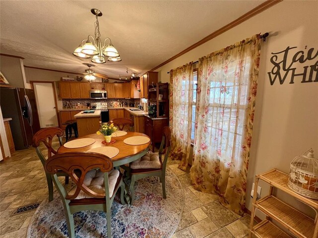 13132 Bluebird Ln, Kingston, OK 73439 - dining space with visible vents, an inviting chandelier, stone finish flooring, a textured ceiling, and crown molding
