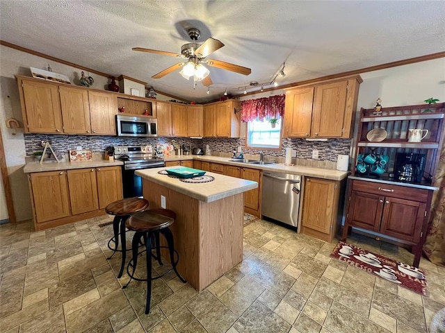 13132 Bluebird Ln, Kingston, OK 73439 - kitchen featuring a kitchen island, ceiling fan, light countertops, appliances with stainless steel finishes, and a sink