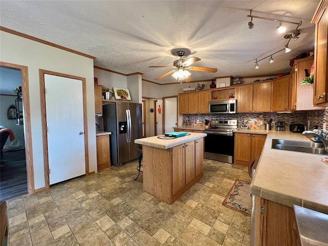 13132 Bluebird Ln, Kingston, OK 73439 - kitchen featuring a kitchen island, a sink, stainless steel appliances, light countertops, and backsplash