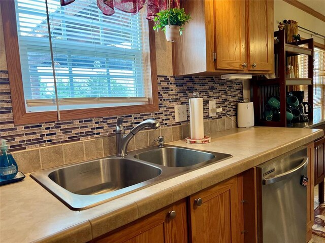 13132 Bluebird Ln, Kingston, OK 73439 - kitchen with brown cabinetry, a sink, light countertops, stainless steel dishwasher, and tasteful backsplash