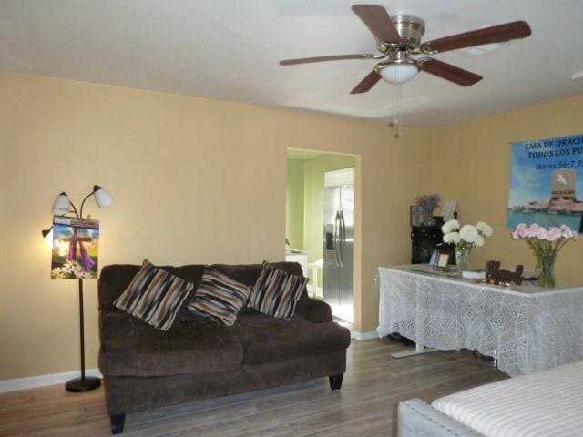 interior space featuring ceiling fan, baseboards, and wood finished floors