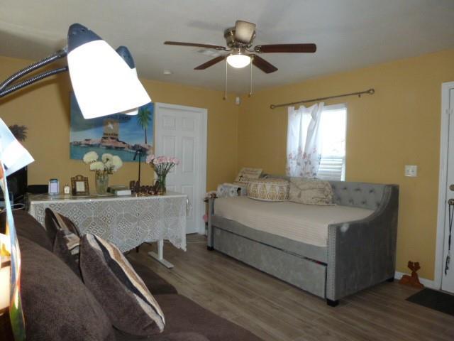 bedroom featuring ceiling fan, wood finished floors, and baseboards