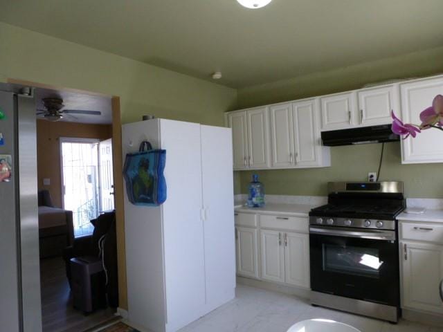 kitchen with under cabinet range hood, white cabinetry, stainless steel appliances, and light countertops