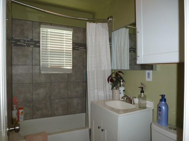 bathroom featuring toilet, shower / tub combo with curtain, and vanity