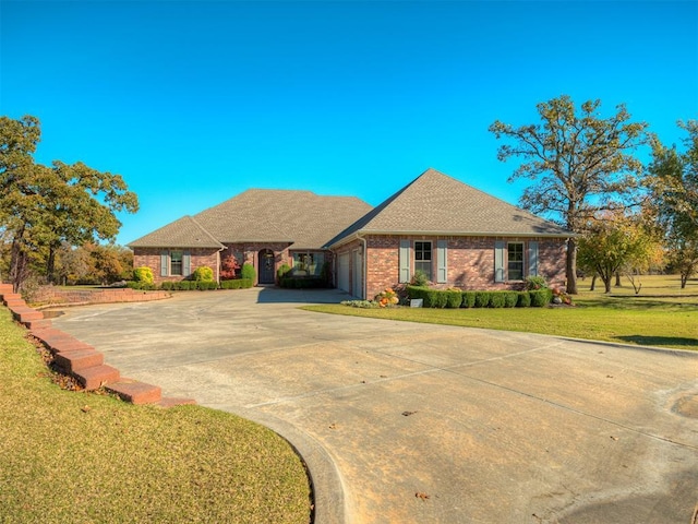 view of front of house with driveway, a front lawn, a shingled roof, a garage, and brick siding