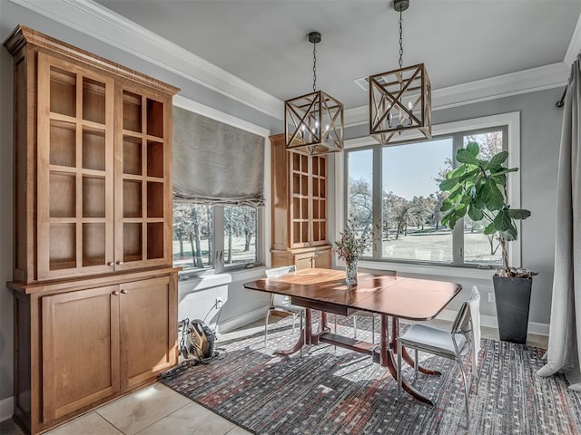 dining space with light tile patterned flooring, crown molding, and baseboards