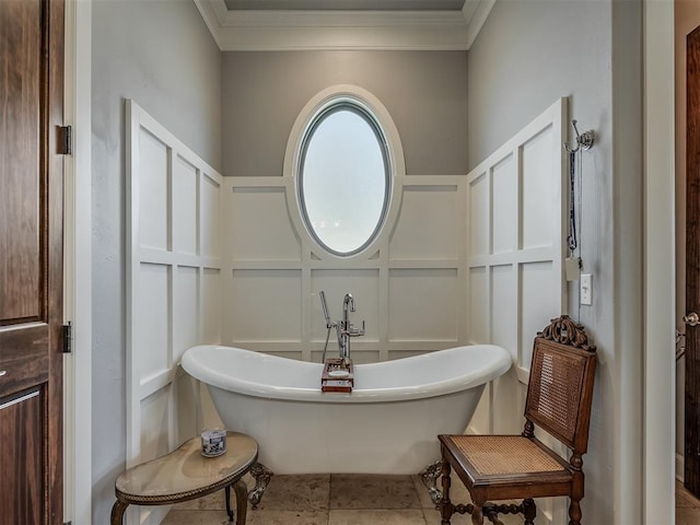 full bath with a freestanding tub, crown molding, and a decorative wall