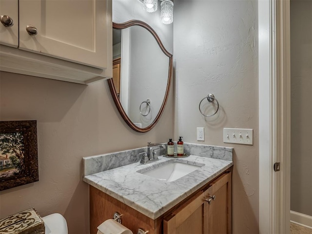 half bathroom with vanity and toilet