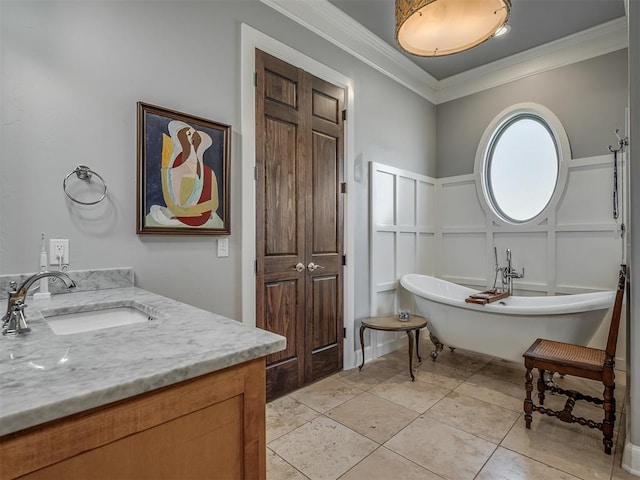 full bathroom featuring vanity, a soaking tub, crown molding, a decorative wall, and tile patterned floors