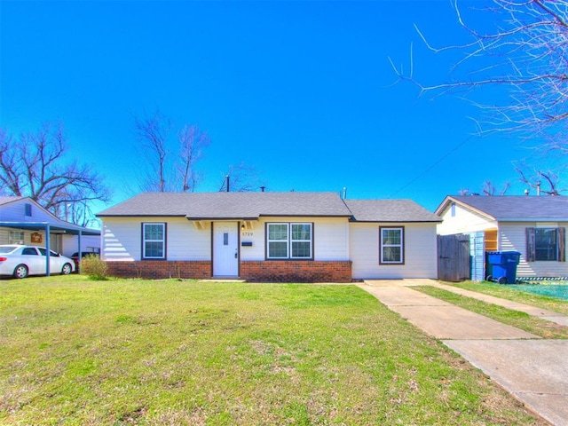 single story home featuring a front yard, fence, and brick siding