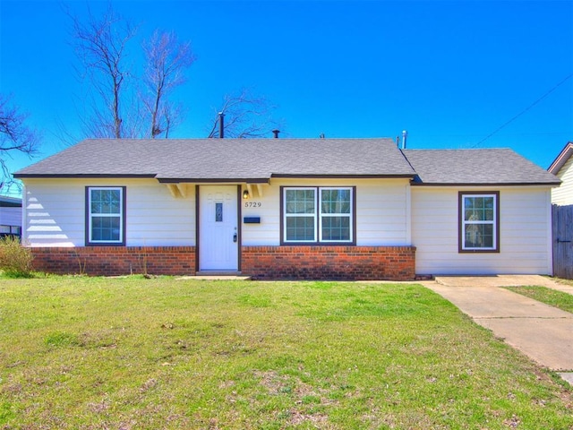 ranch-style house with a front yard, brick siding, and a shingled roof