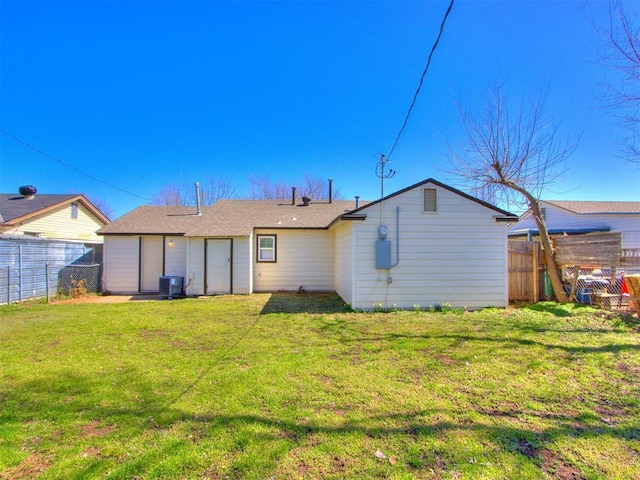 back of house featuring cooling unit, a fenced backyard, and a yard