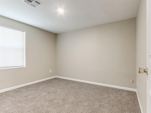 spare room featuring visible vents, carpet flooring, and baseboards