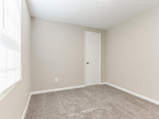 carpeted empty room with baseboards