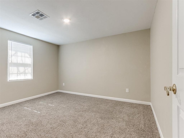 carpeted empty room featuring baseboards and visible vents