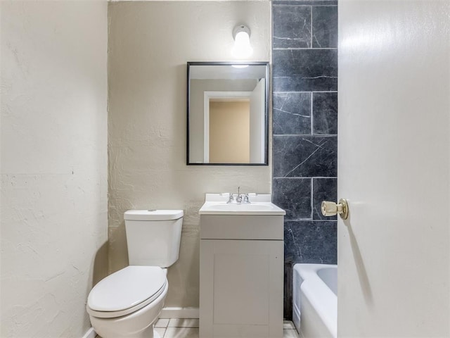 bathroom with toilet, vanity, a tub to relax in, and a textured wall