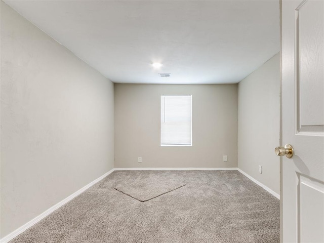 carpeted spare room with visible vents and baseboards