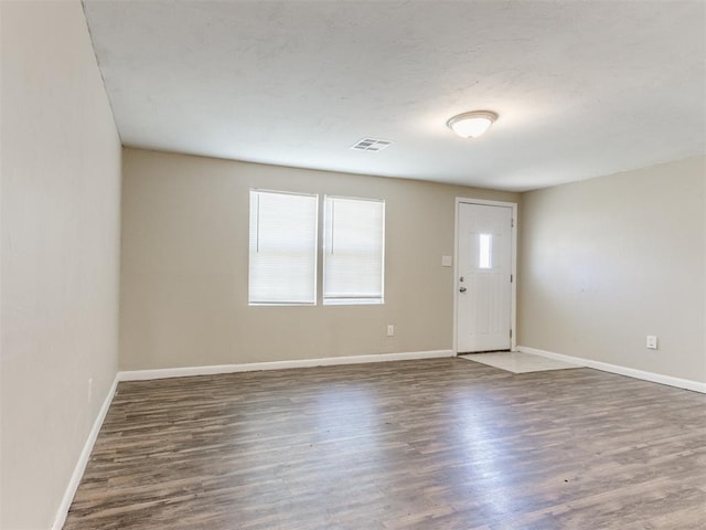 entrance foyer with visible vents, baseboards, and wood finished floors