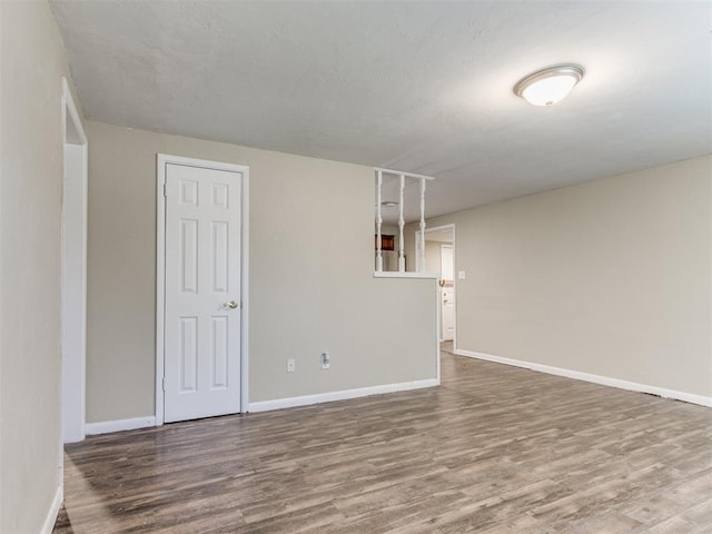 unfurnished room with wood finished floors and baseboards