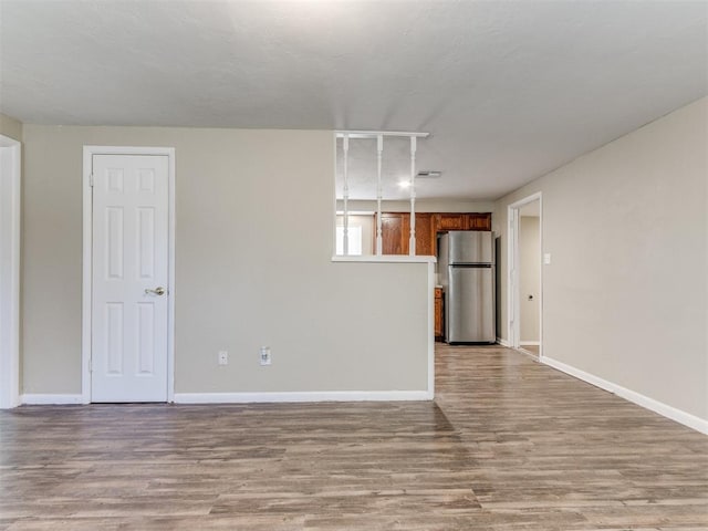 spare room featuring baseboards and wood finished floors