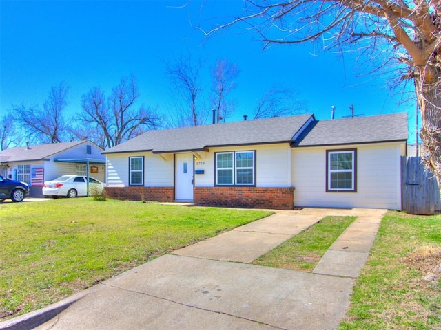 single story home with a front yard, fence, and brick siding