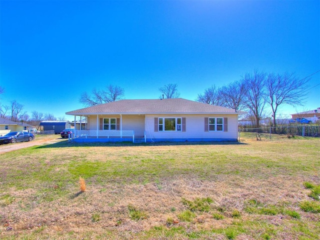 view of front of house with covered porch, fence, and a front lawn