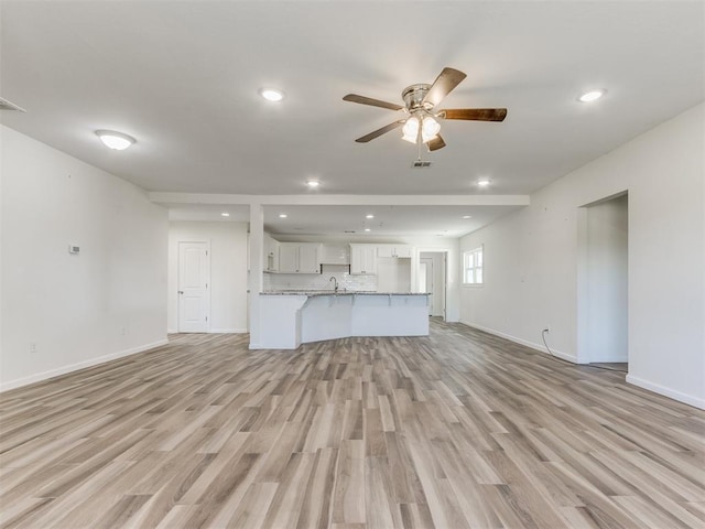 unfurnished living room featuring recessed lighting, baseboards, ceiling fan, and light wood finished floors