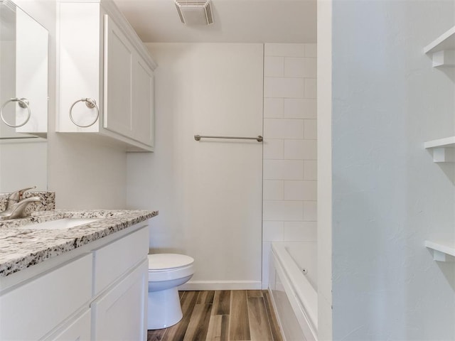 bathroom with visible vents, baseboards, toilet, wood tiled floor, and vanity