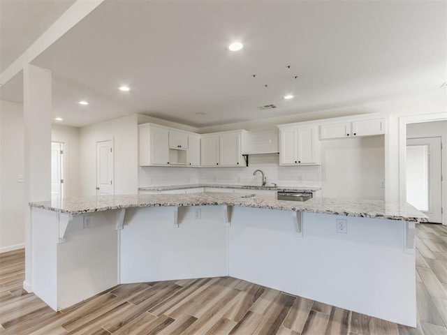 37005 Lake Rd, Shawnee, OK 74801 - kitchen featuring a sink, white cabinets, a breakfast bar, and light wood finished floors