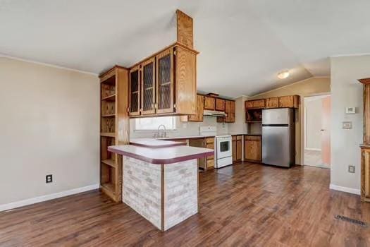 kitchen featuring under cabinet range hood, brown cabinets, a peninsula, freestanding refrigerator, and electric range