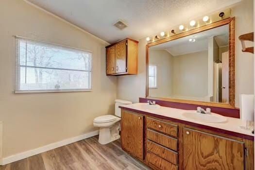 bathroom with toilet, a sink, wood finished floors, baseboards, and vaulted ceiling