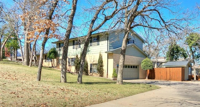 view of side of property with fence, driveway, a garage, a lawn, and brick siding