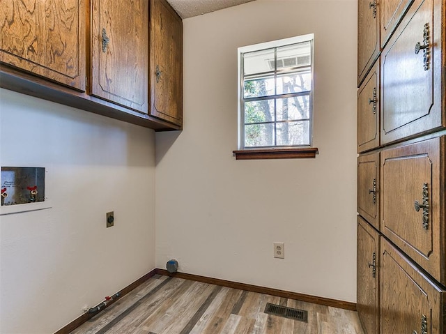2000 N Alexander Ln, Bethany, OK 73008 - laundry area with cabinet space, electric dryer hookup, hookup for a washing machine, and light wood-type flooring