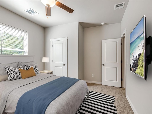 carpeted bedroom with a ceiling fan, visible vents, and baseboards