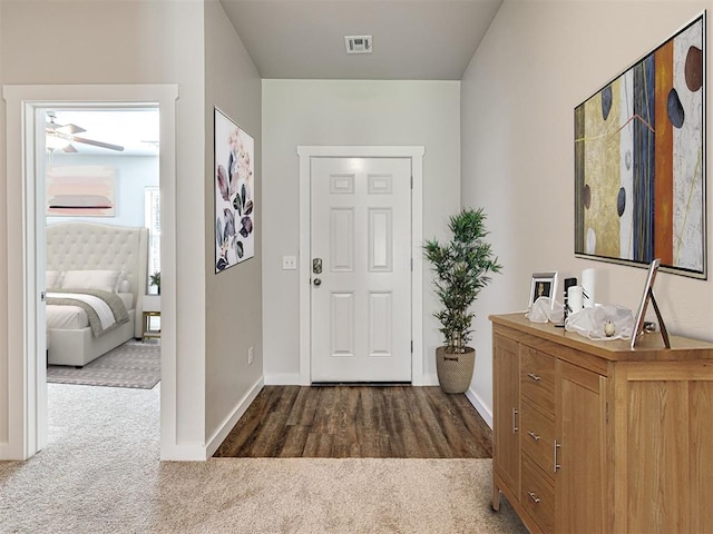 entryway with carpet flooring, visible vents, and baseboards