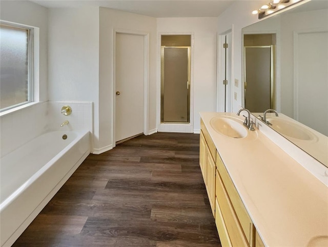 bathroom with wood finished floors, a stall shower, vanity, and a bath