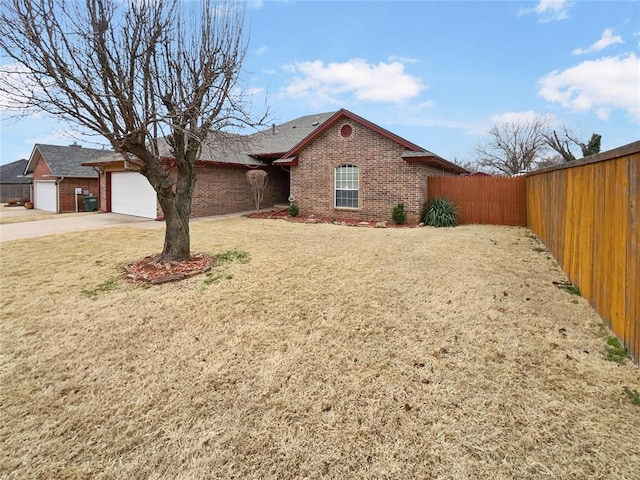 single story home with driveway, fence, a front yard, an attached garage, and brick siding