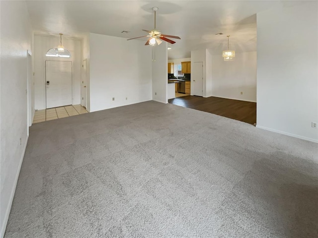 unfurnished living room featuring ceiling fan and dark carpet