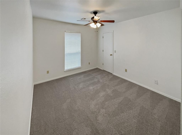 empty room featuring carpet flooring, baseboards, visible vents, and ceiling fan