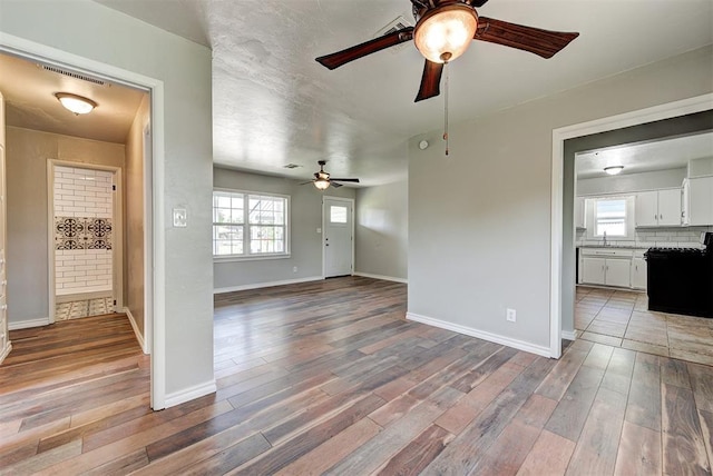 2625 SW 46th St, Oklahoma City, OK 73119 - unfurnished living room featuring ceiling fan, wood finished floors, and baseboards