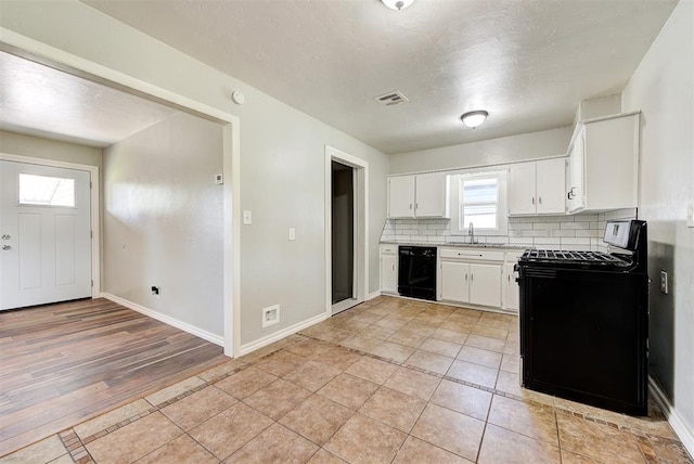 2625 SW 46th St, Oklahoma City, OK 73119 - kitchen with black appliances, decorative backsplash, white cabinetry, light countertops, and baseboards