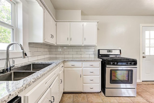 2625 SW 46th St, Oklahoma City, OK 73119 - kitchen with stainless steel range with gas stovetop, a sink, plenty of natural light, and white cabinets