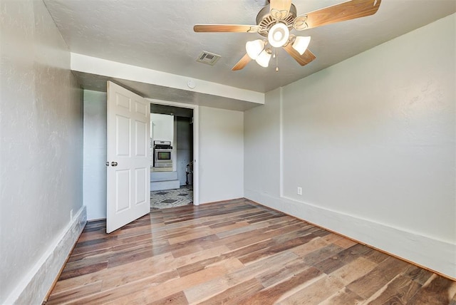 2625 SW 46th St, Oklahoma City, OK 73119 - unfurnished bedroom featuring wood finished floors and a ceiling fan