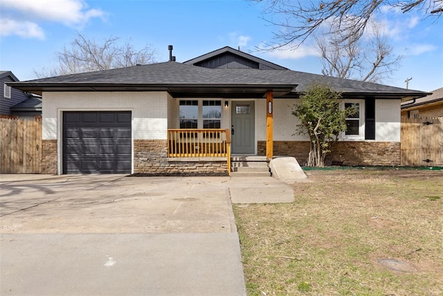 view of front facade featuring fence, brick siding, a garage, and driveway