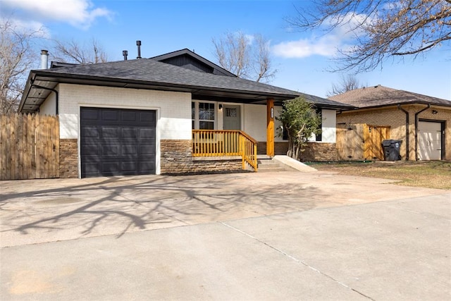 view of front facade with an attached garage, fence, brick siding, and driveway