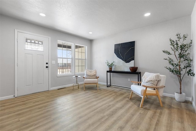 entryway with recessed lighting, a textured ceiling, and light wood-style flooring