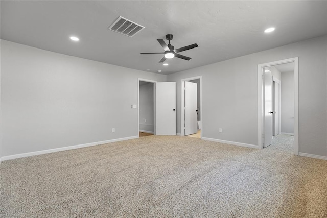 empty room with visible vents, light colored carpet, baseboards, and ceiling fan