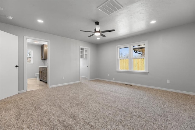 unfurnished bedroom featuring recessed lighting, visible vents, light carpet, and multiple windows