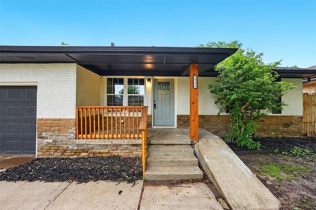 1731 Carlisle Rd, The Village, OK 73120 - property entrance with brick siding, an attached garage, and covered porch